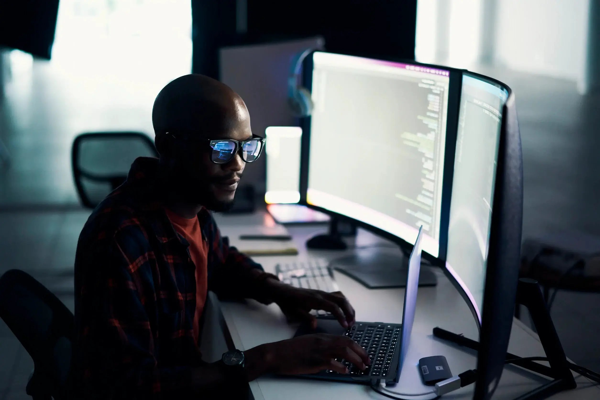 man-at-desk-with-screens